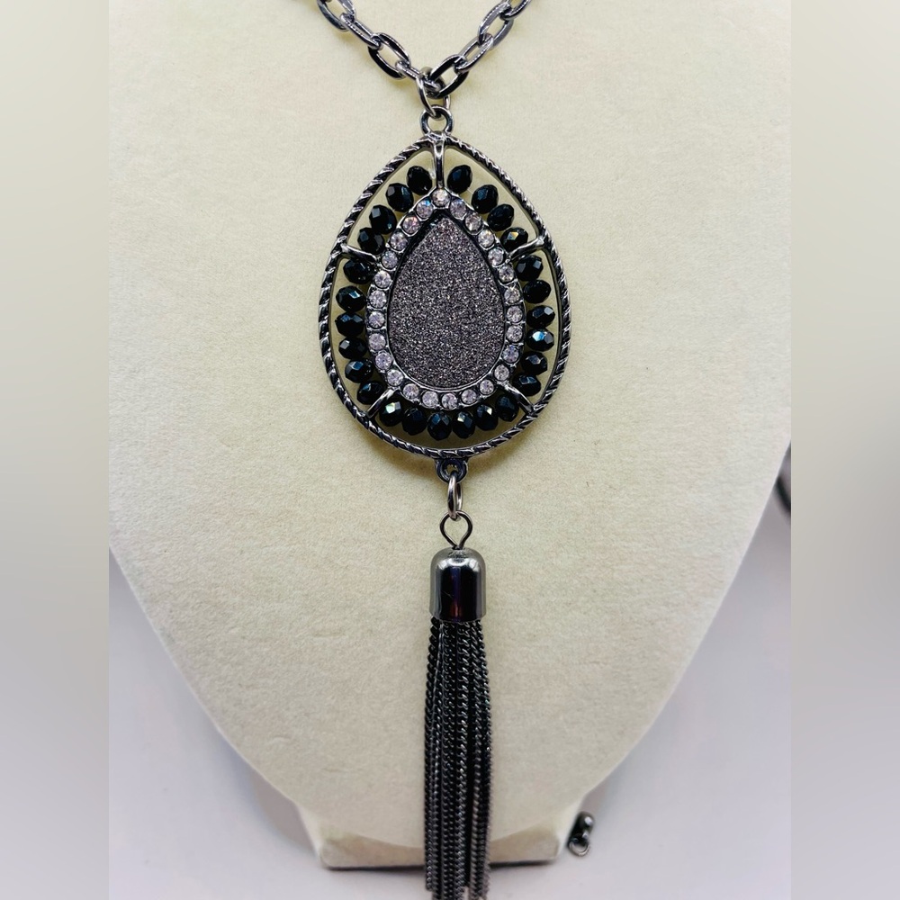 Black and silver rhinestone beaded teardrop pendant with a black chain tassel.